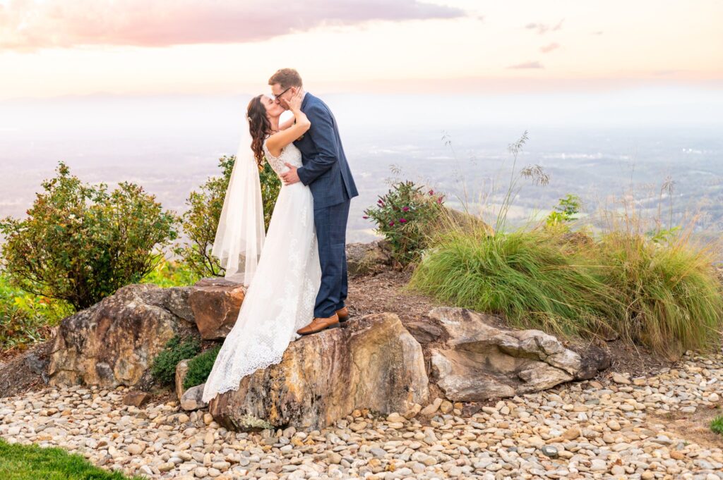 wedding photograph, husband and wife kissing with a mountain view in the background.