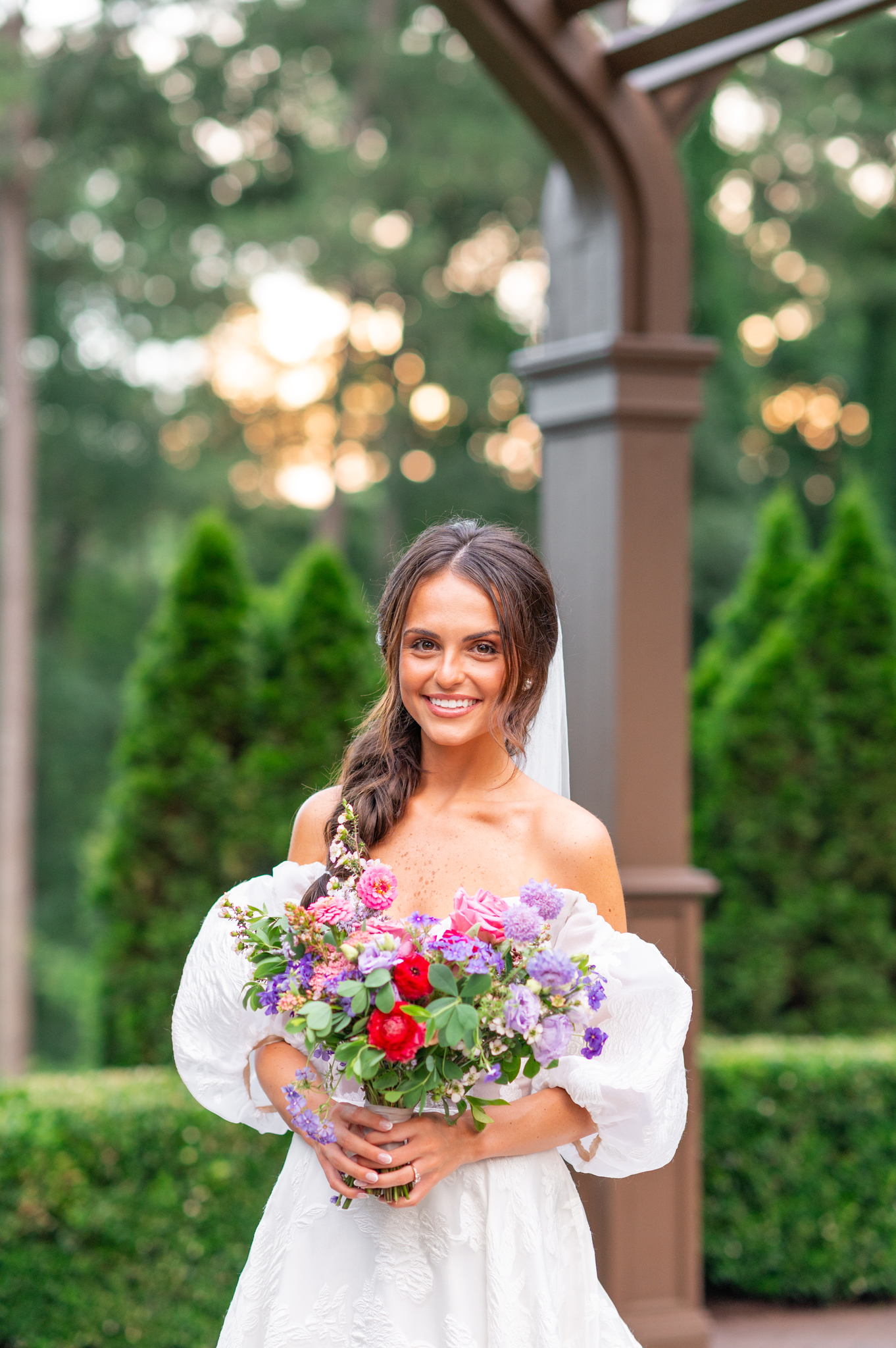 Photo of Allison in her wedding gown smiling and looking at the camera