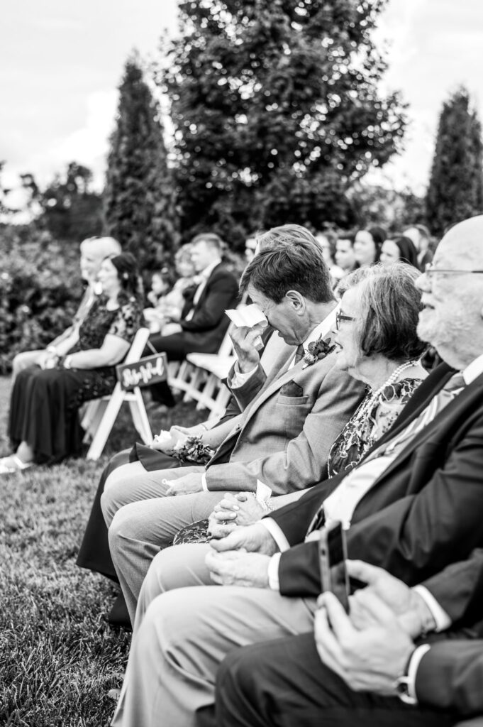 dad wiping his eyes at his daughter's wedding